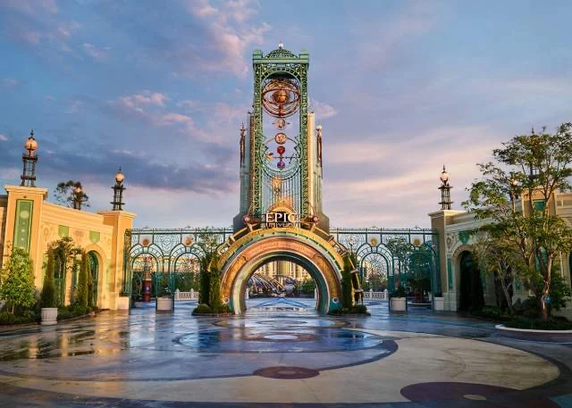 Ornate Epic Universe entrance portal beneath a pastel evening sky